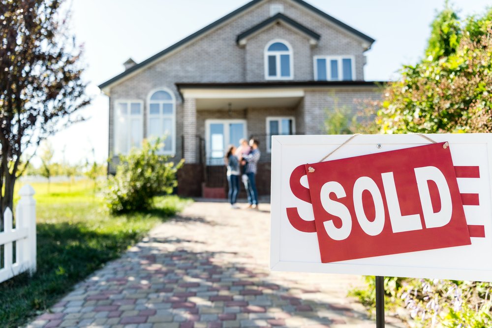 Sold,House,With,Blurred,Family,On,Background